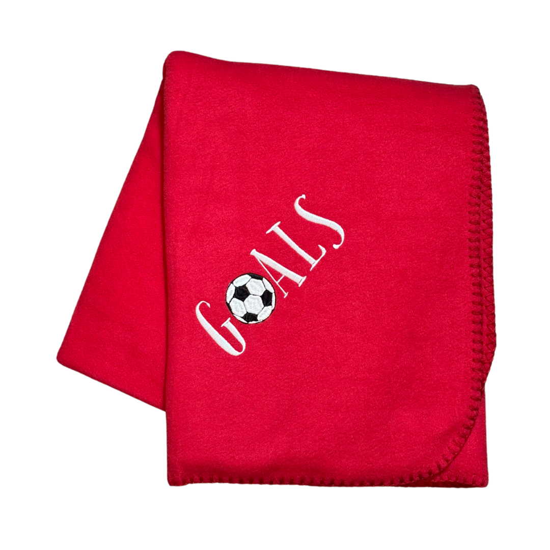 Red blanket with 'GOALS' and a soccer ball design in white