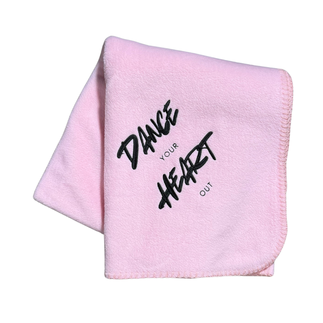 Pink blanket with 'Dance Your Heart Out' text in black thread embroidery