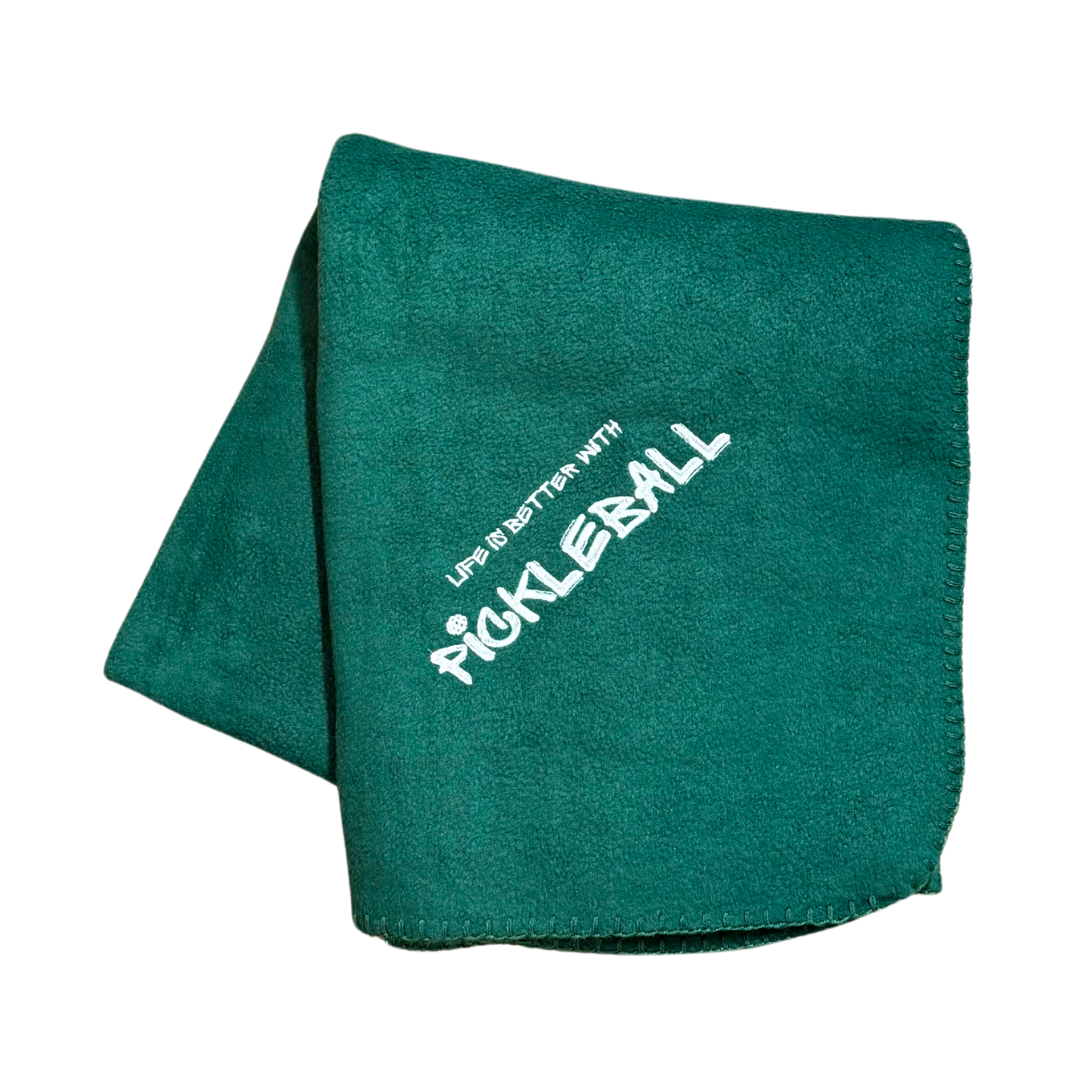 Green blanket with 'Pickleball' text in white stitching