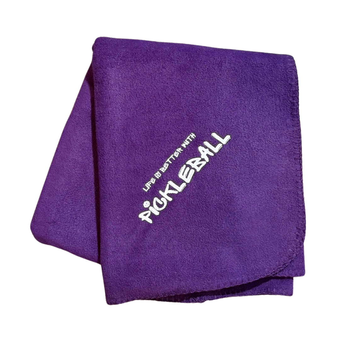 Purple fleece blanket with 'Pickleball' text in white embroidery