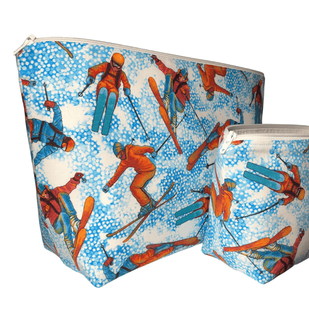 two makeup bags with skiers on blue and white background