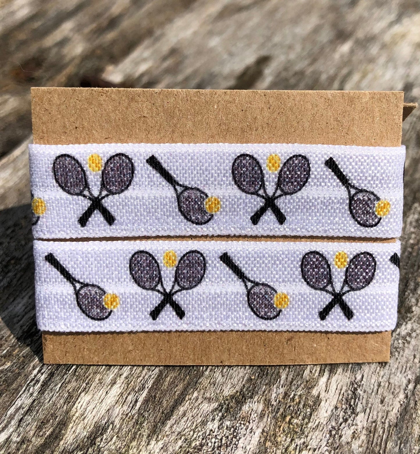white sleeve clips with black tennis rackets and yellow tennis balls