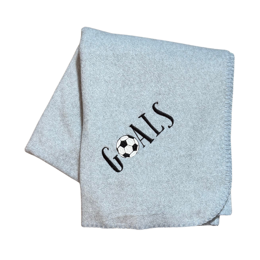 Light gray blanket with 'GOALS' and a soccer ball design