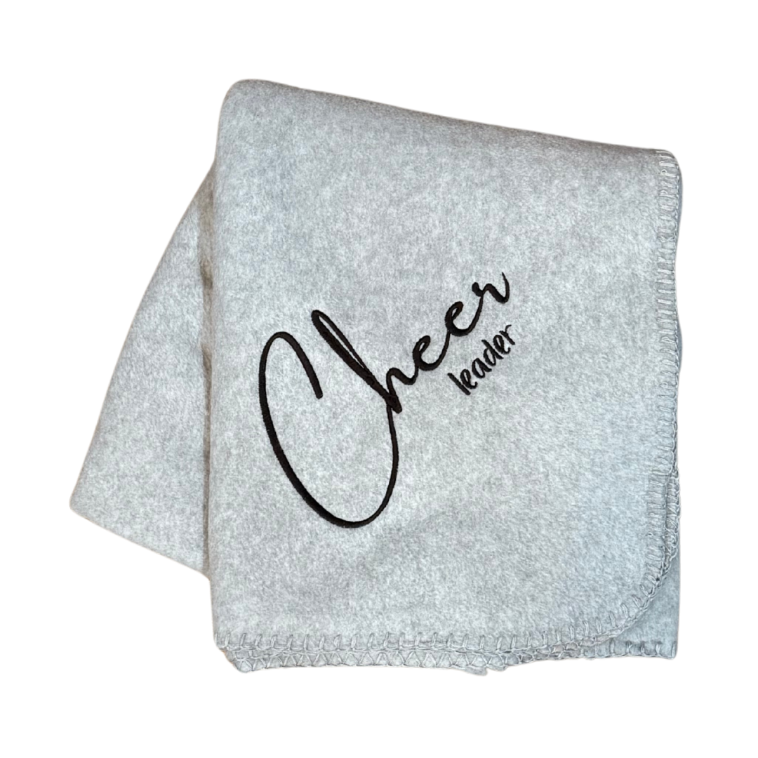 Gray blanket with 'Cheer leader' text in black stitching