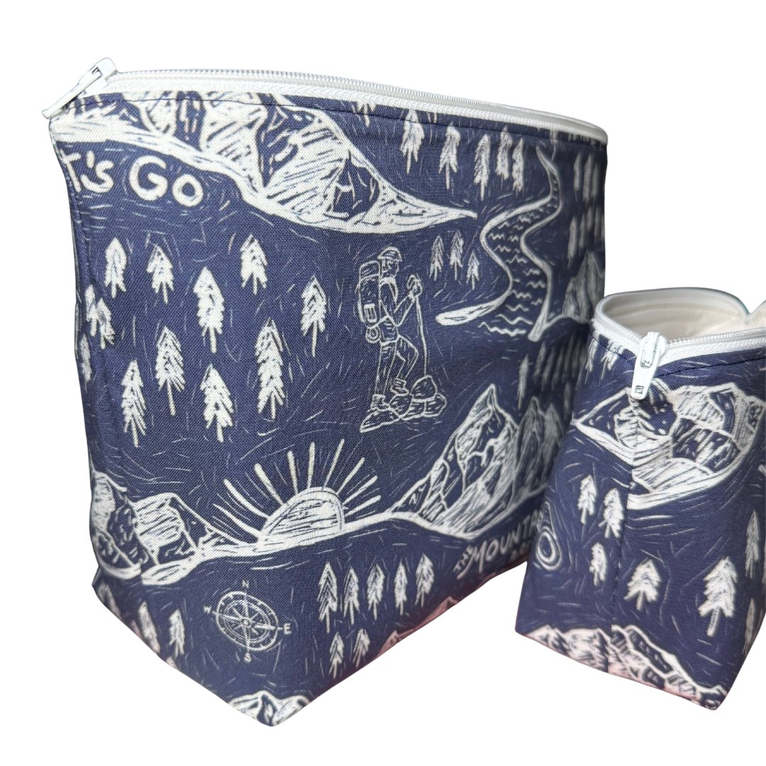 Two blue pouches with white nature-themed designs on a navy blue background