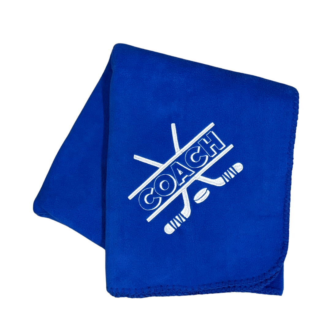 Blue fleece blanket with 'COACH' and hockey stick design in white stitching