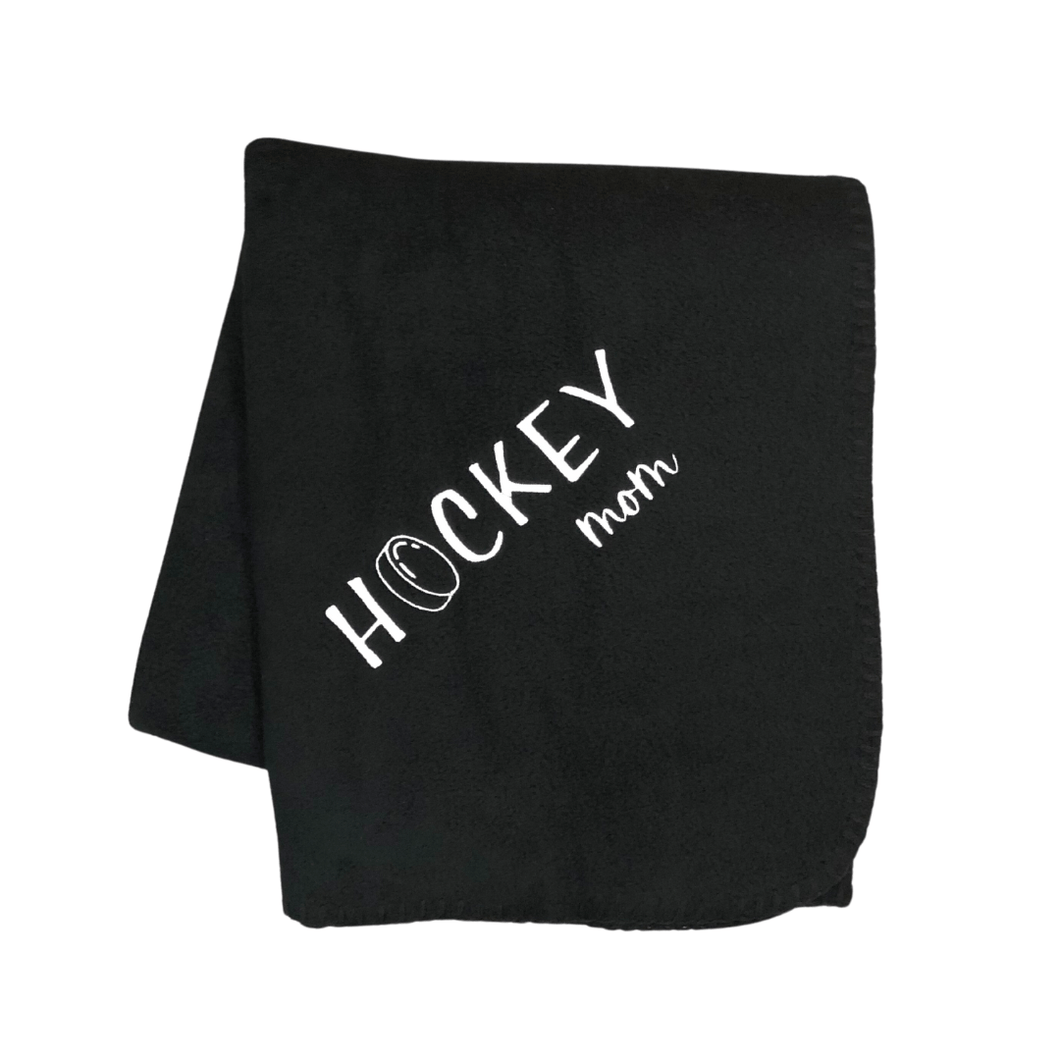 black hockey mom blanket with white stitching and a hockey puck as the O in hockey