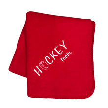Load image into Gallery viewer, red hockey mom blanket with a hockey puck as the O in hockey
