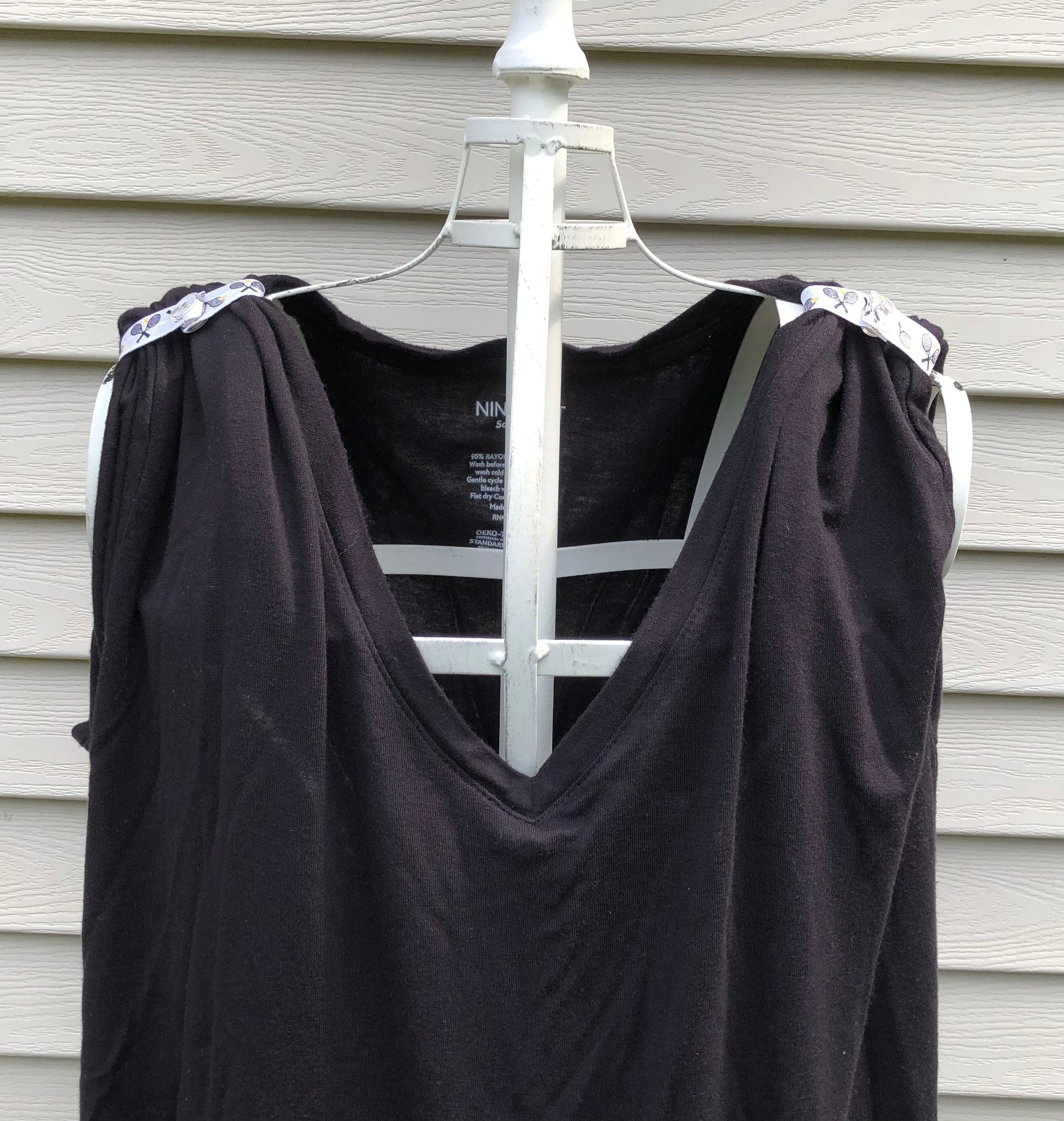 black tshirt on mannaquin with sleeves rolled up and held in place with sleeve clips