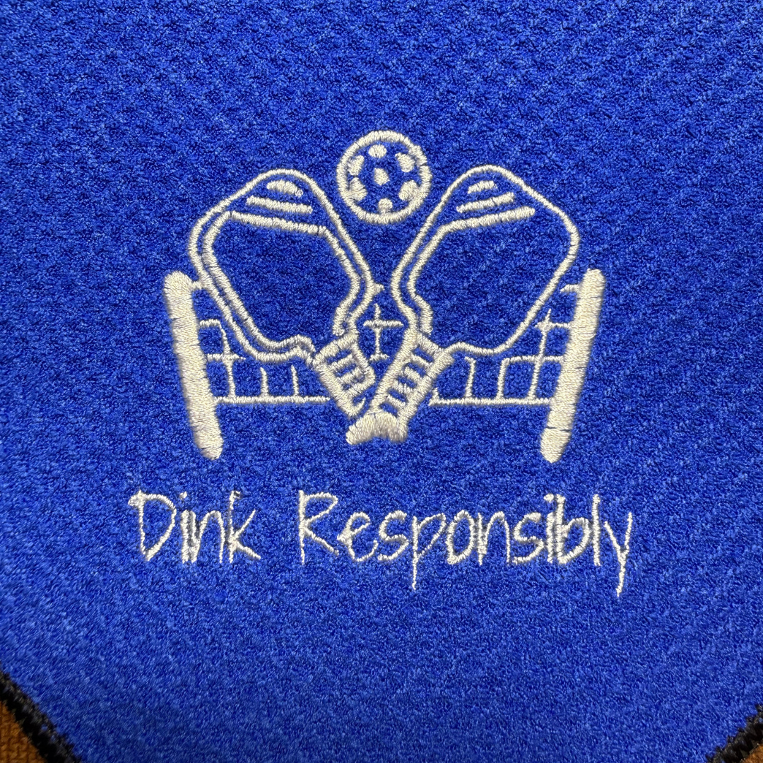 Blue towel with white pickleball text and design on a blue background