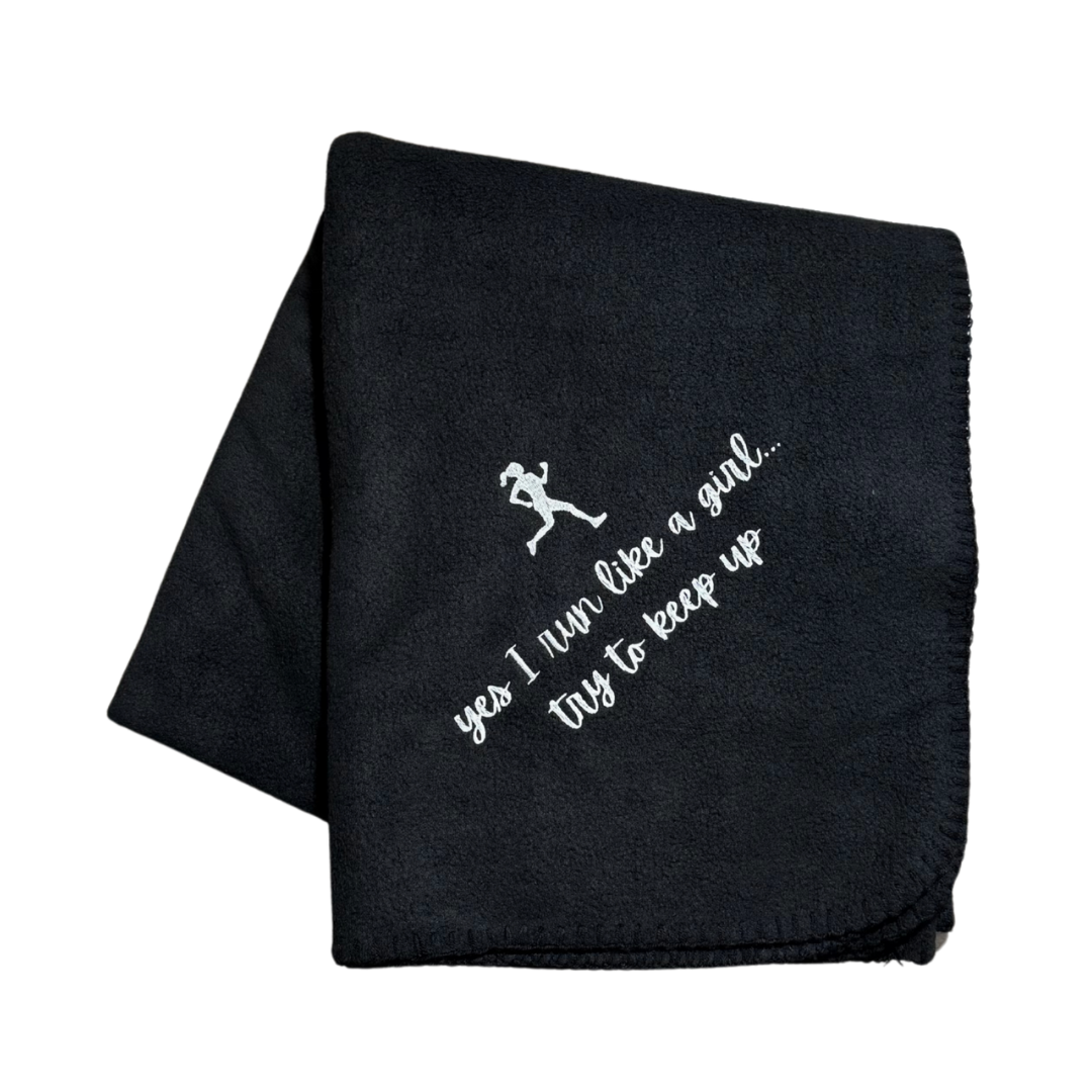 Black blanket with white text and graphic in white embroidery