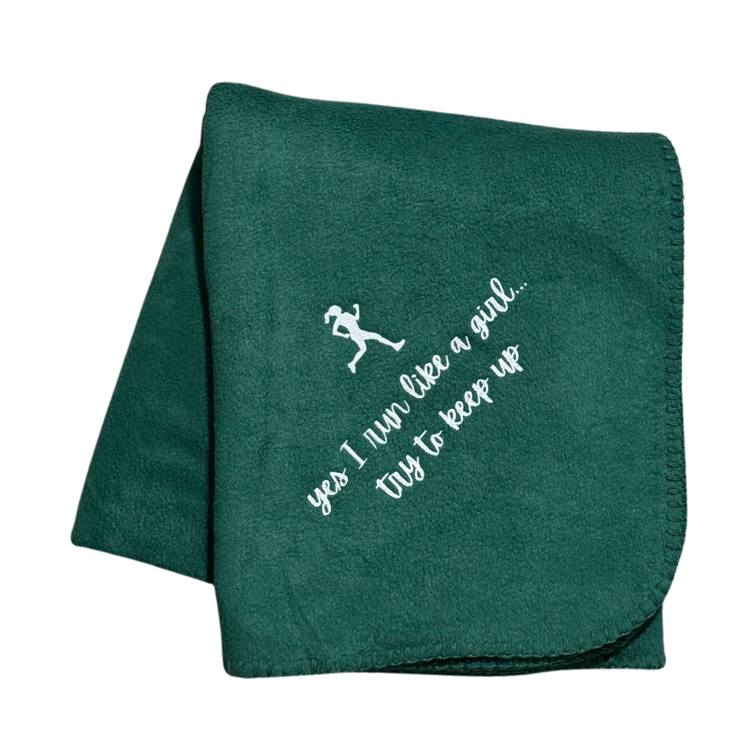 Green blanket with white text and running girl graphic