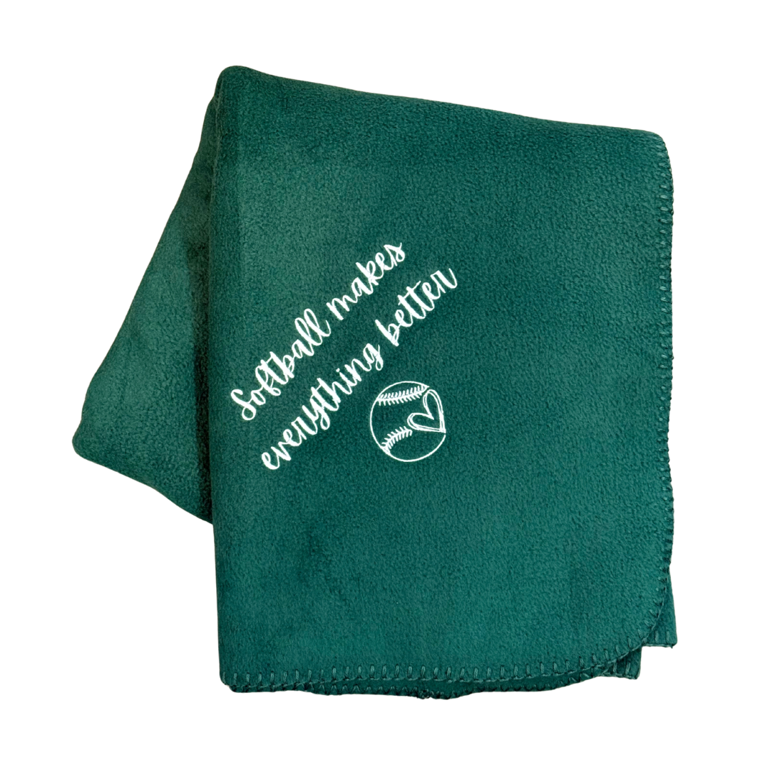 Green blanket with 'Softball makes everything better' text and softball graphic in white embroidery