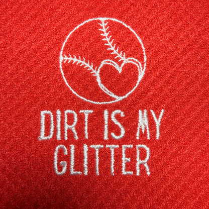 Red towel with white embroidered text 'Dirt is my Glitter' and a baseball heart design.