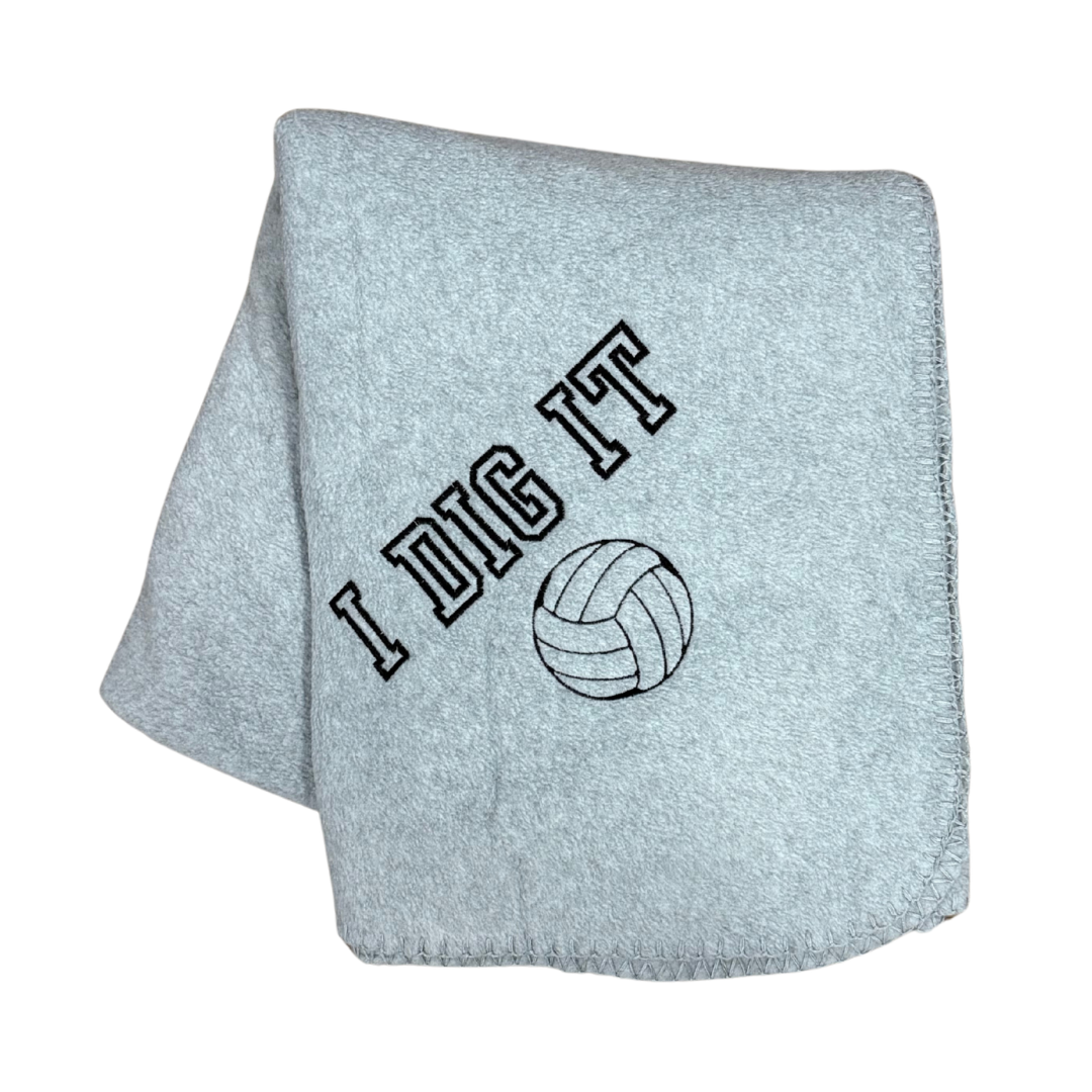 gray fleece blanket with I Dig It and a volleyball embroidered in black thread