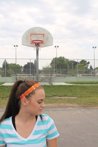 side view of girl wearing a basketball headband on a basketball court