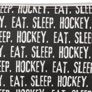 zipper pouch with eat sleep hockey printed in white on a black background