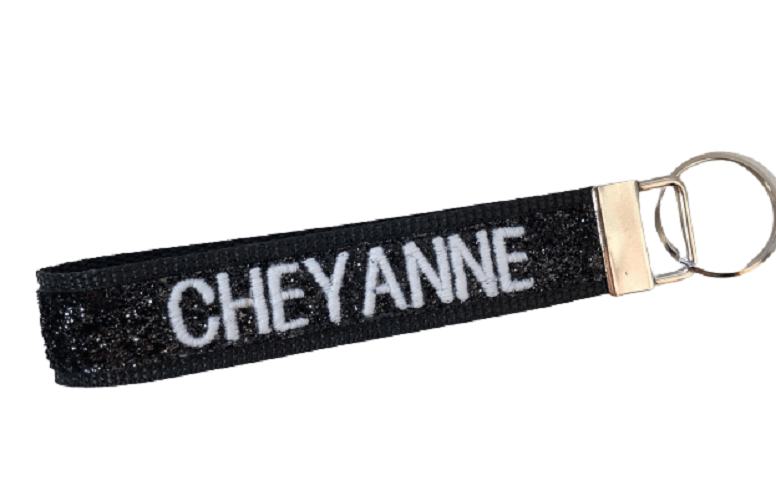 black glitter keychain personalized with cheyanne in white