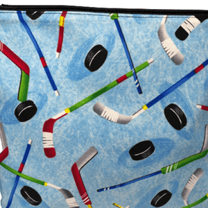 blue hockey fabric with multi colored hockey sticks and hockey pucks